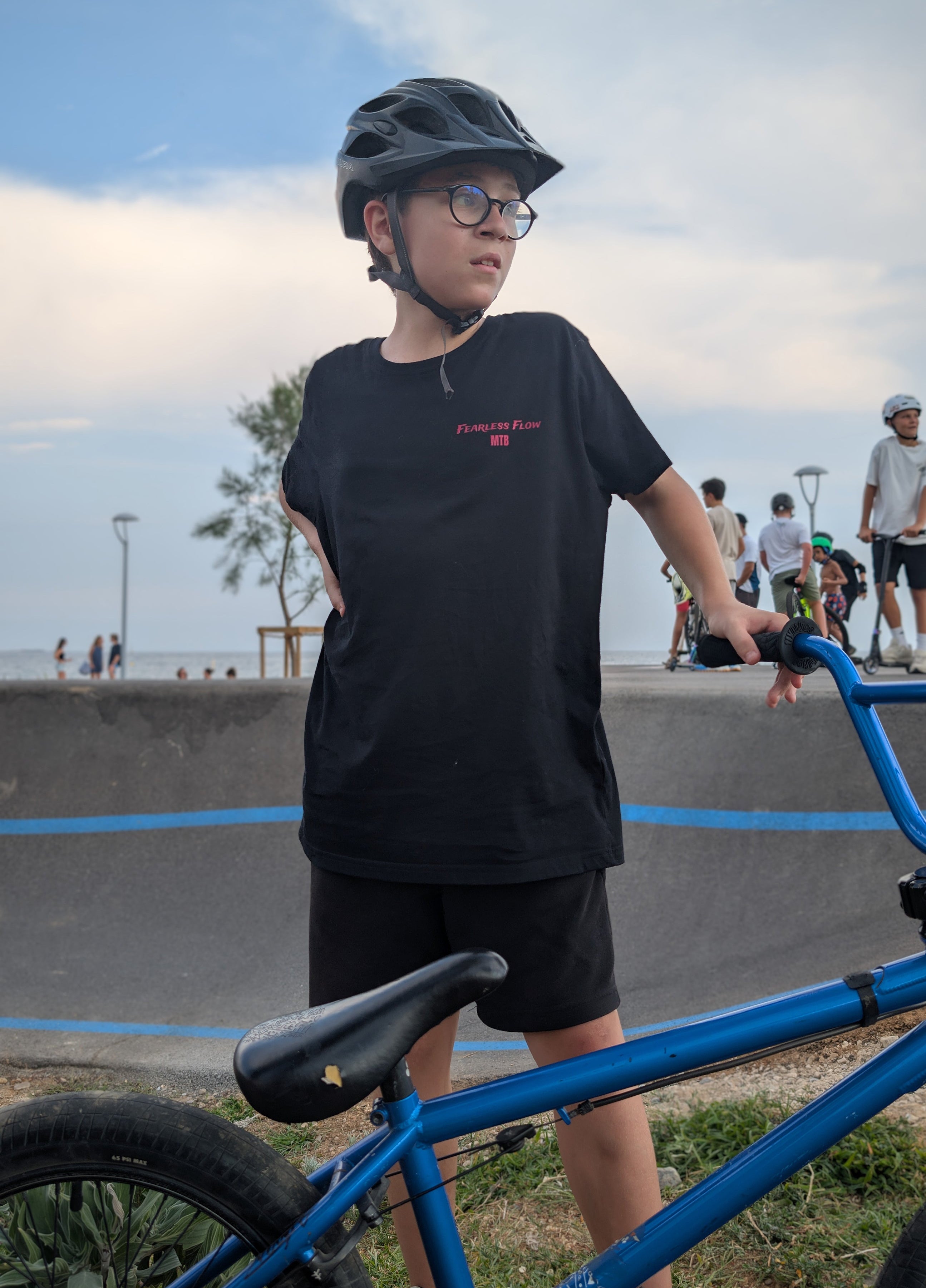 Tee-shirt noir Fearless Flow premier drop pour rider VTT freeride, porté par l’ambassadeur Nélio sur son BMX Fly Bike pump track de cagnes sur mer, vue de face.