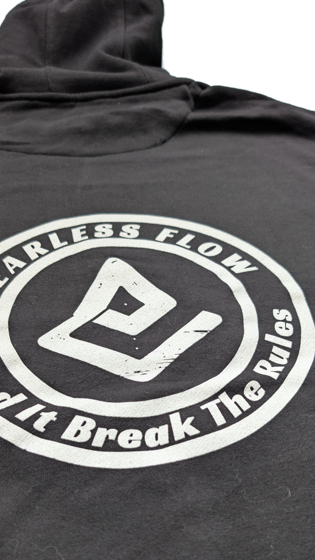 Détail du flocage blanc du logo Fearless Flow Send It Break The Rules sur hoodie streetwear VTT noir