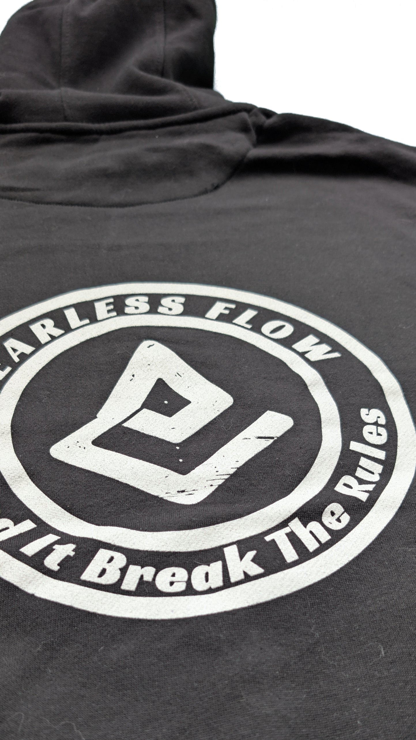 Détail du flocage blanc du logo Fearless Flow Send It Break The Rules sur hoodie streetwear VTT noir