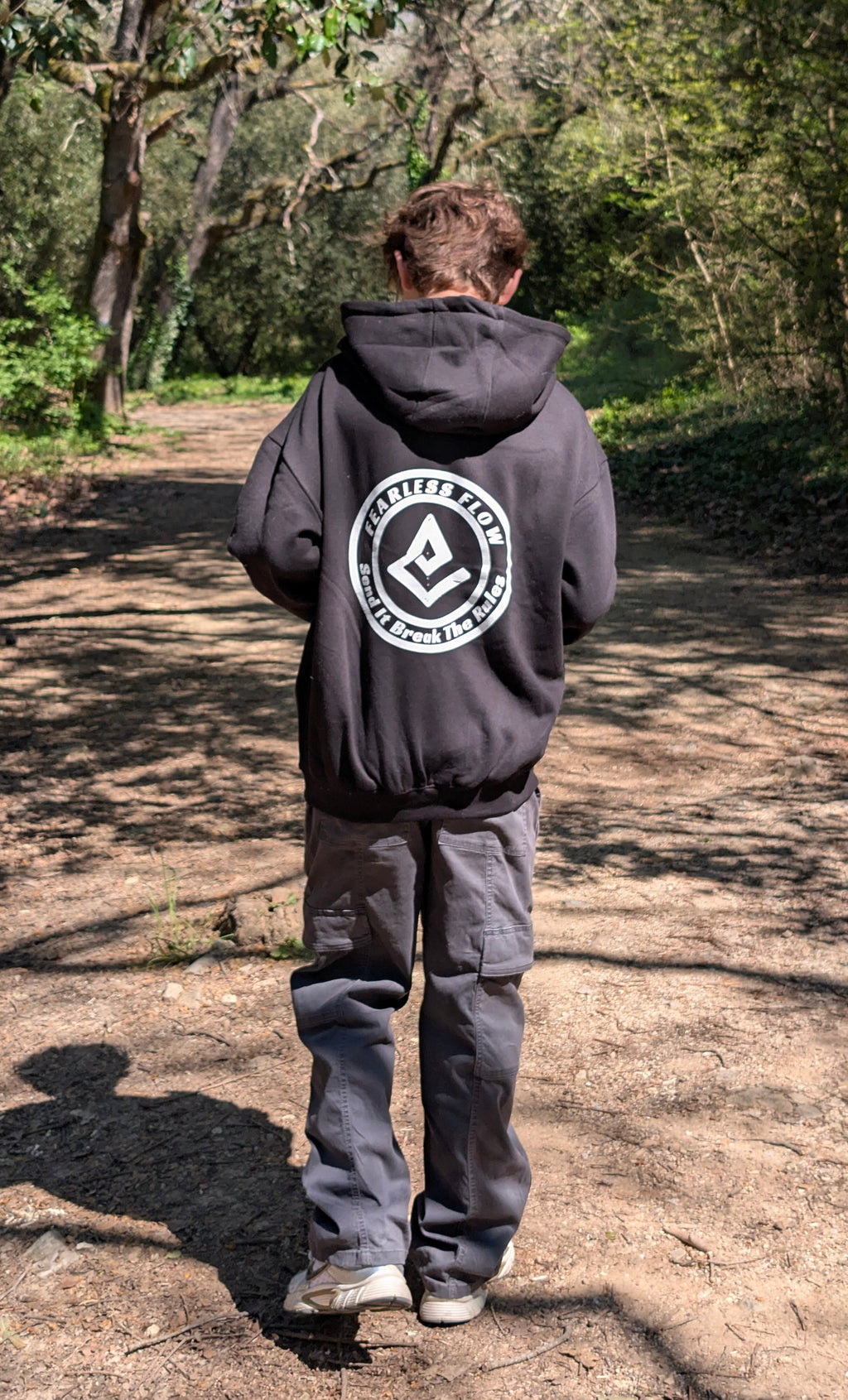 Hoodie streetwear VTT Fearless Flow noir avec logo Send It Break The Rules, porté en forêt sur un sentier d'enduro