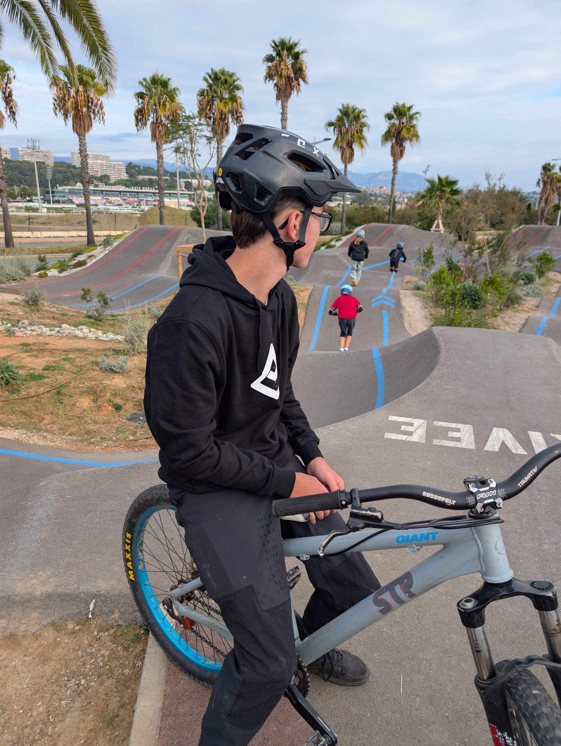 Timéo assis sur son dirt au pump track de Cagnes-sur-Mer, regardant l’horizon