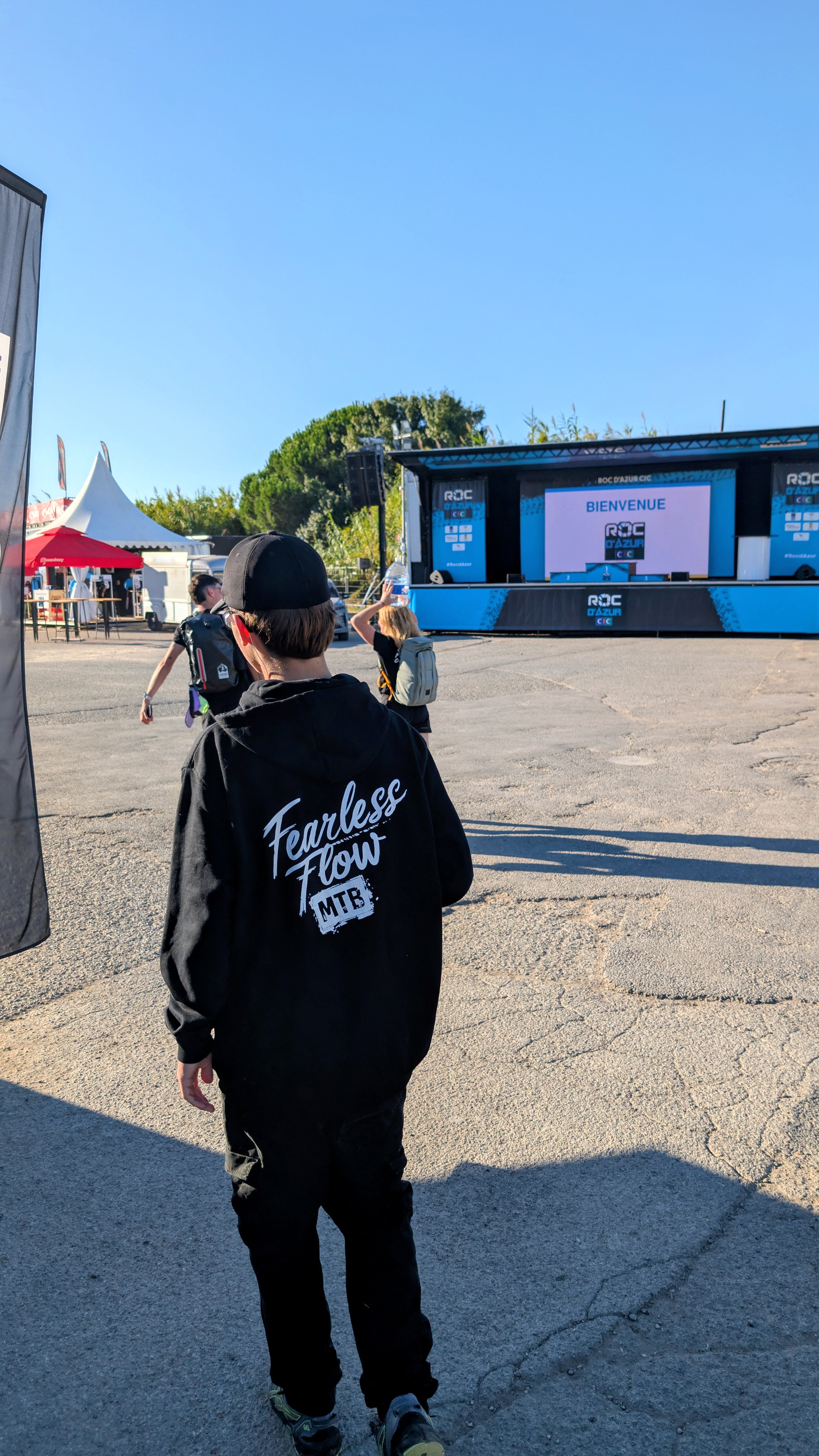 Hoodie noir Fearless Flow pour rider VTT freeride, porté par l’ambassadeur Timéo au Roc D'azur 2025, vue de dos.