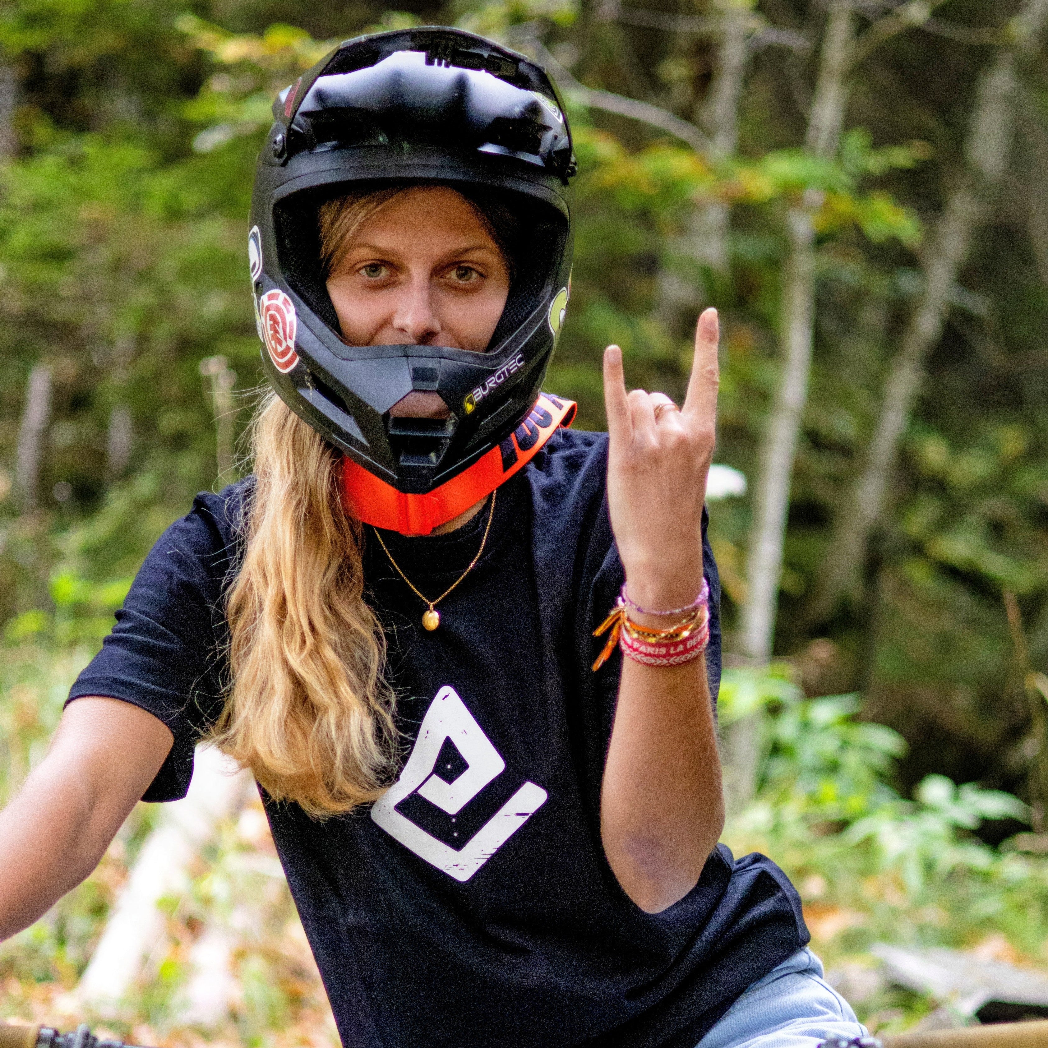 Hoodie noir Fearless Flow pour rider VTT freeride, porté par l’ambassadrice Mathilde sur son DH Commencal au bike park, vue de face.