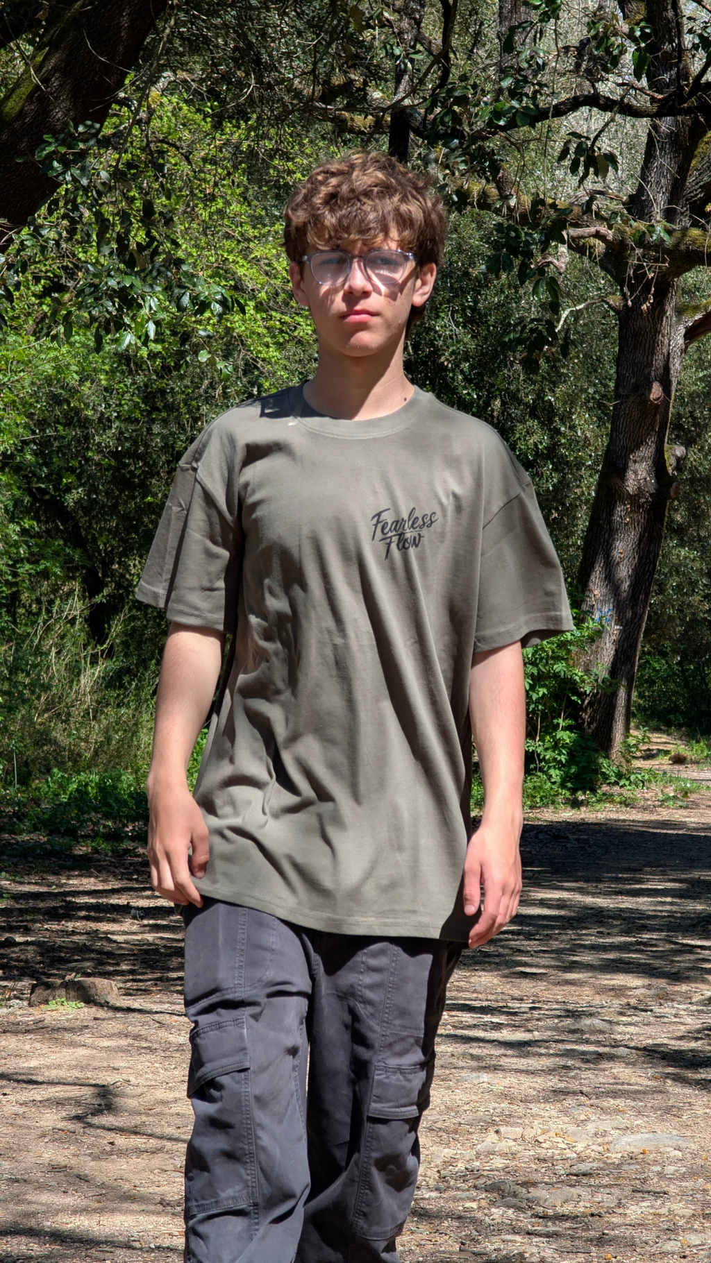Tee-shirt streetwear VTT Fearless Flow kaki avec logo poitrine, coupe oversize portée en extérieur sur un sentier en forêt